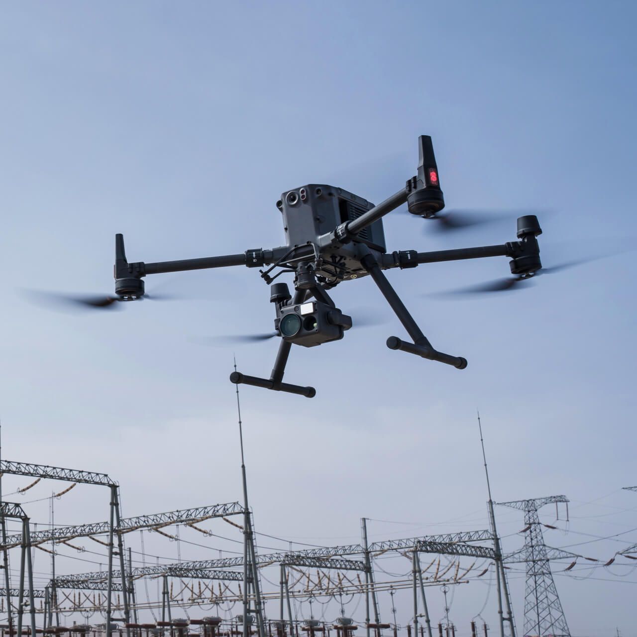 A drone is flying over a row of power lines