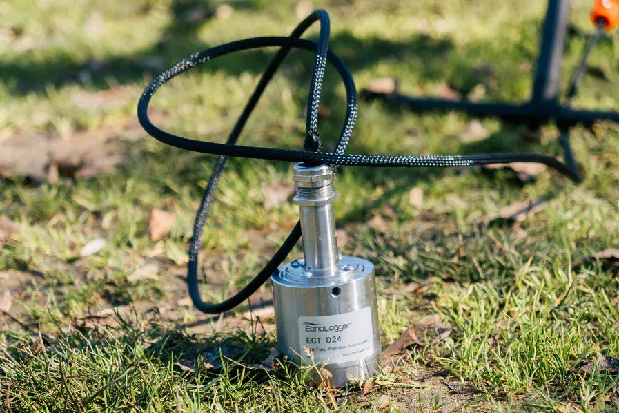 A drone with a camera attached to it is sitting on the ground.