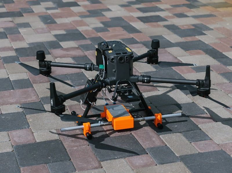 A drone with a camera attached to it is sitting on a tripod.