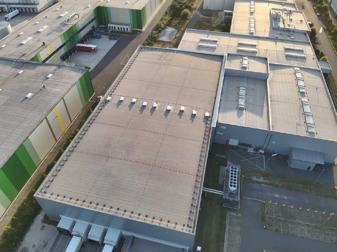 A wind turbine is sitting in the middle of a field of sunflowers.