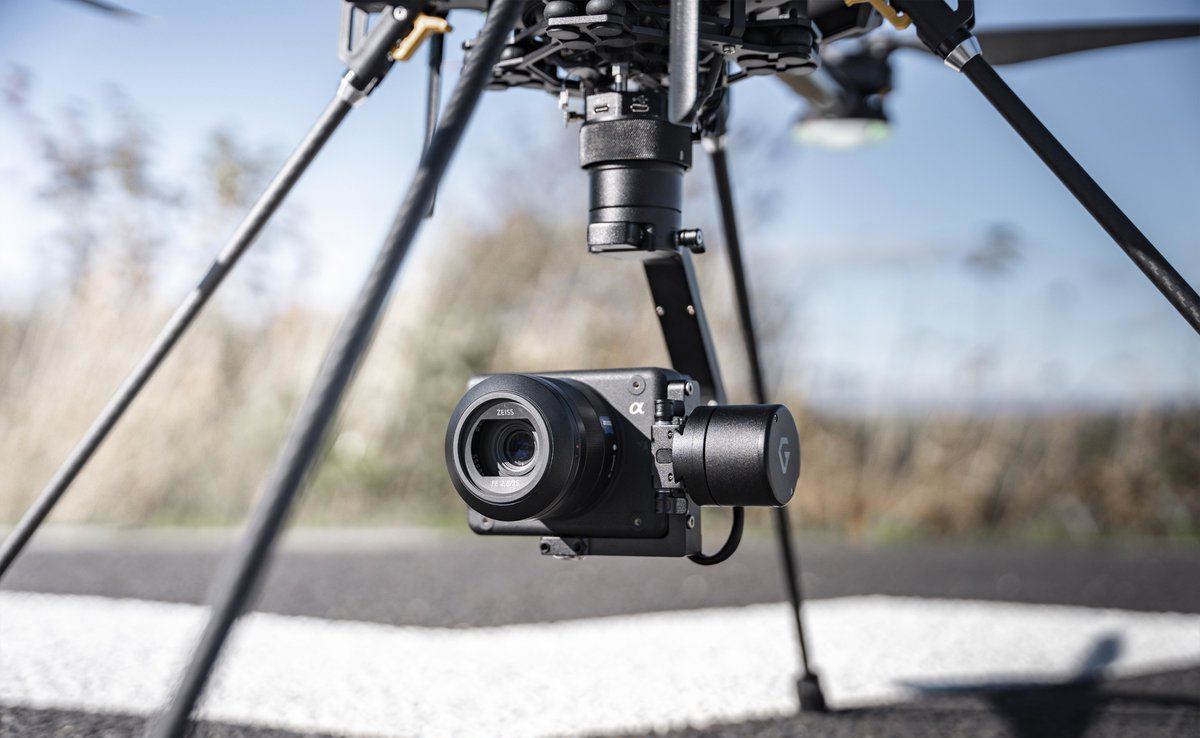 A drone with a camera attached to it is sitting on a tripod.