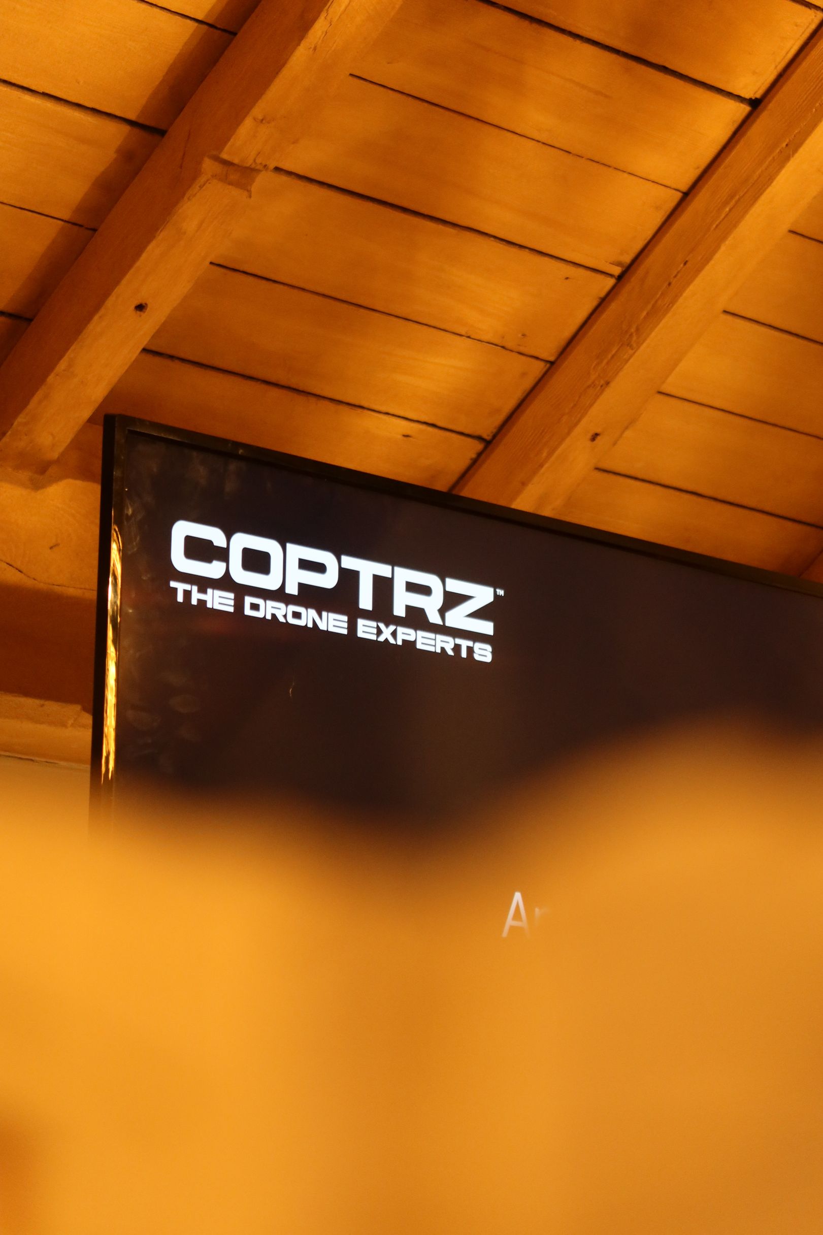 A sign that says coptraz on it is under a wooden ceiling