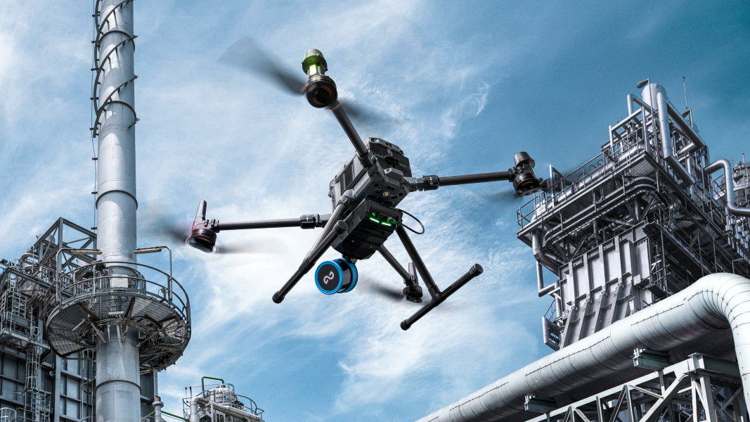 Drohne fliegt in der Nähe einer Industrieanlage, möglicherweise zu Inspektions- oder Überwachungszwecken.