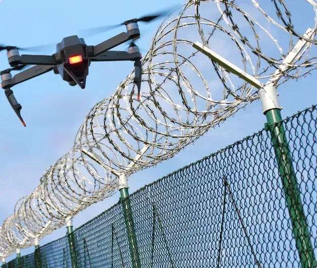 A drone is flying over a barbed wire fence