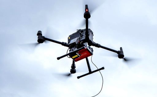 A drone with a camera attached to it is sitting on a tripod.
