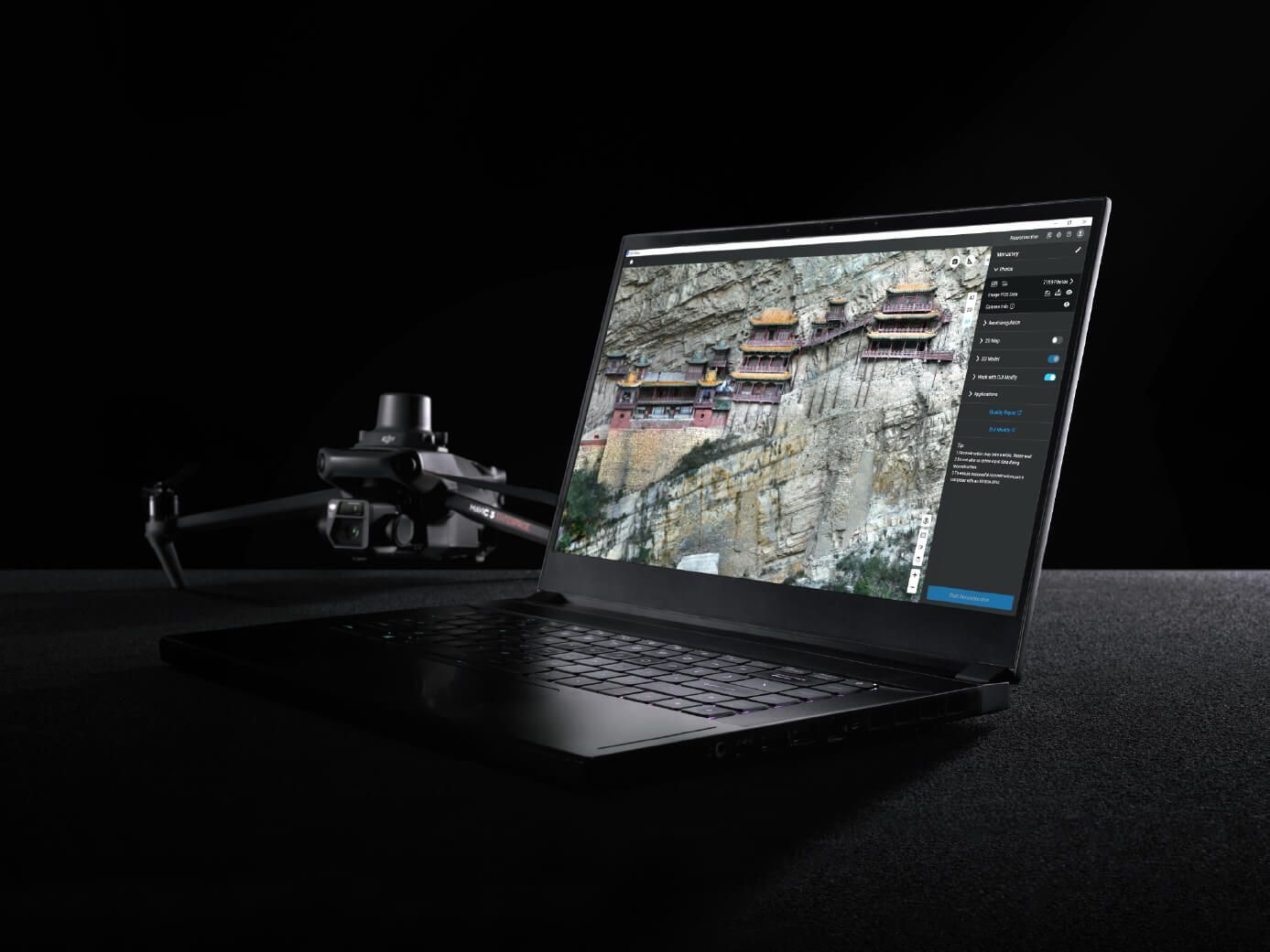 A laptop computer is sitting on a table next to a drone.