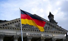 A german flag is flying in front of a building