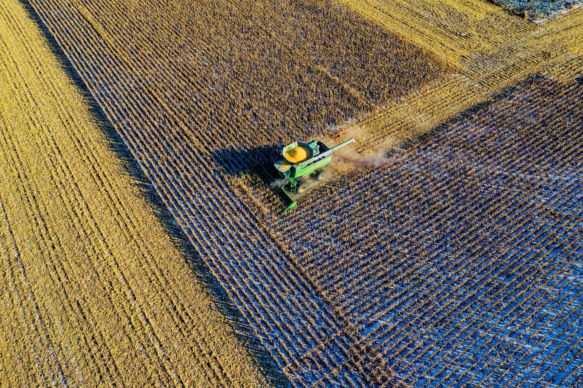An aerial view of a tractor plowing a field.