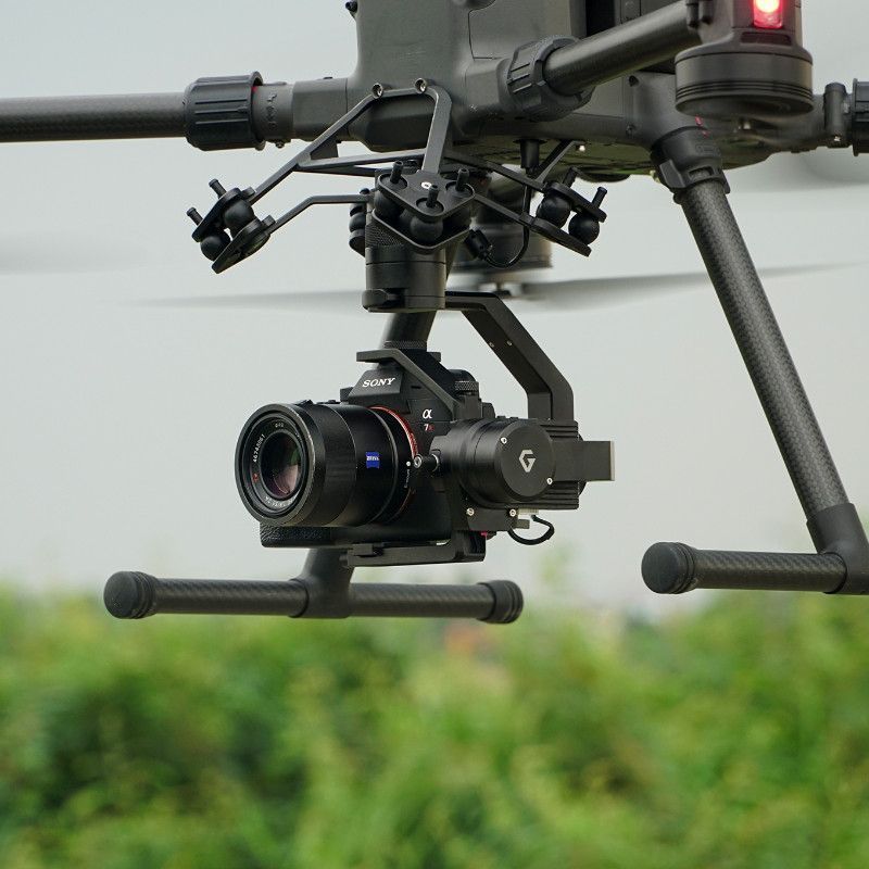 A camera attached to a drone with the letter g on it