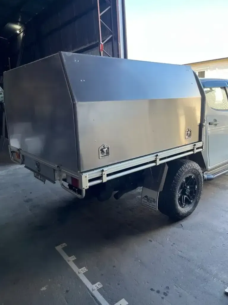 A Truck With a Stainless Steel Canopy is Parked in a Garage — HTH Sheetmetal Mackay in Mackay, QLD