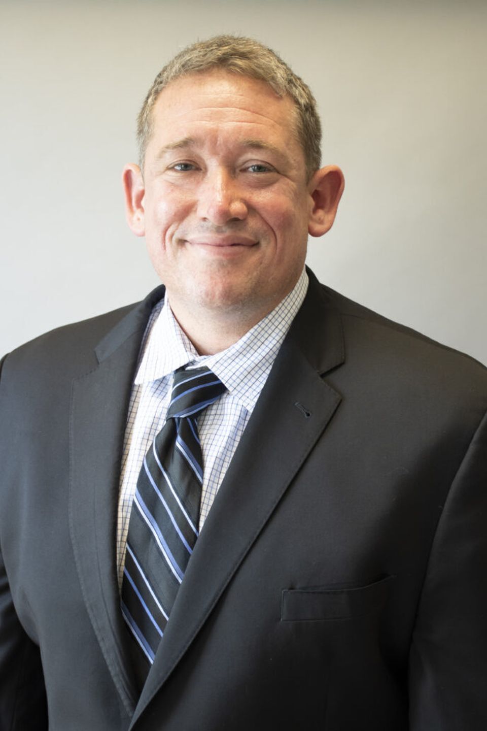 A man in a suit and tie is smiling for the camera.