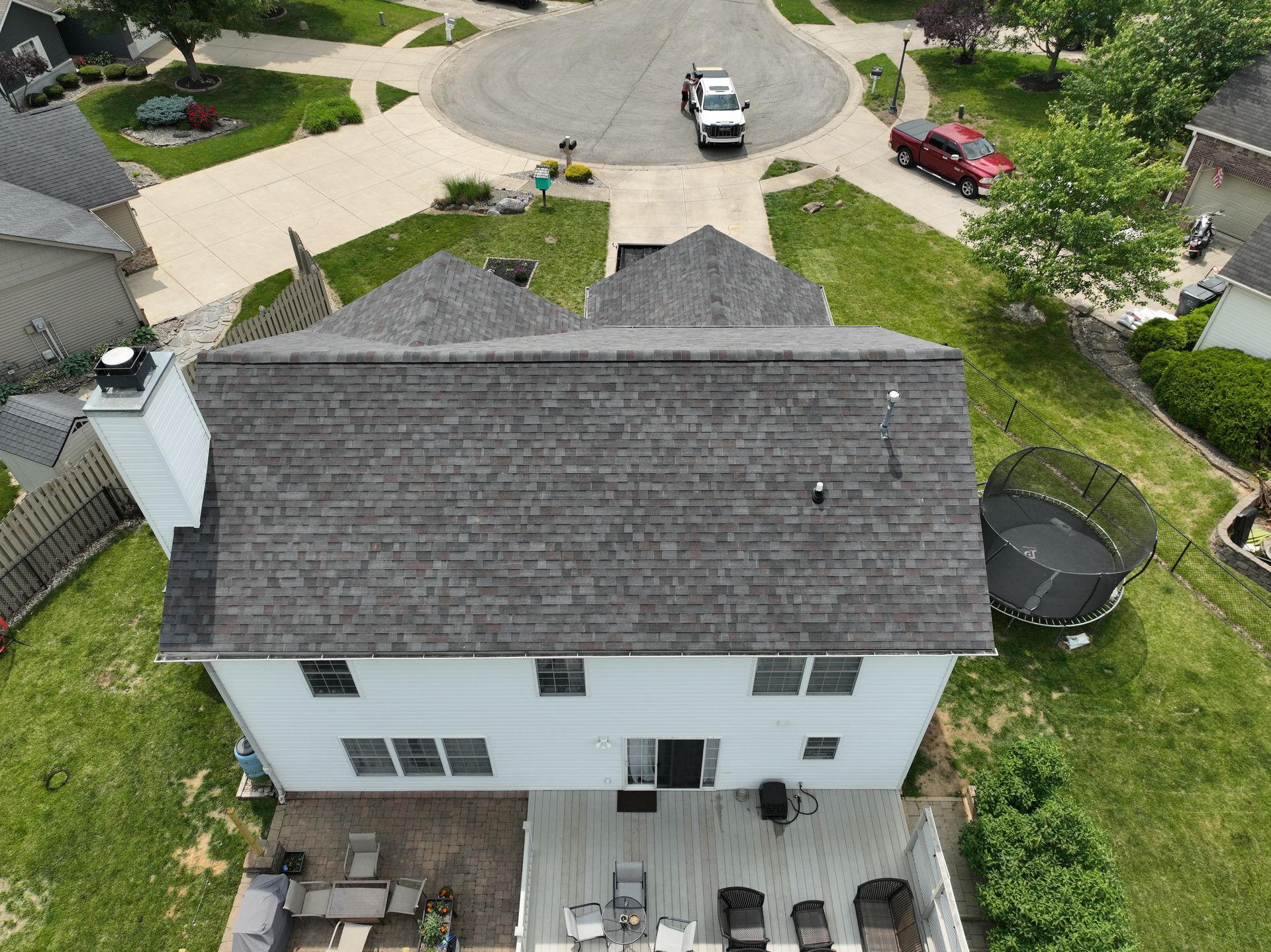 An aerial view of a house with a trampoline in the backyard.