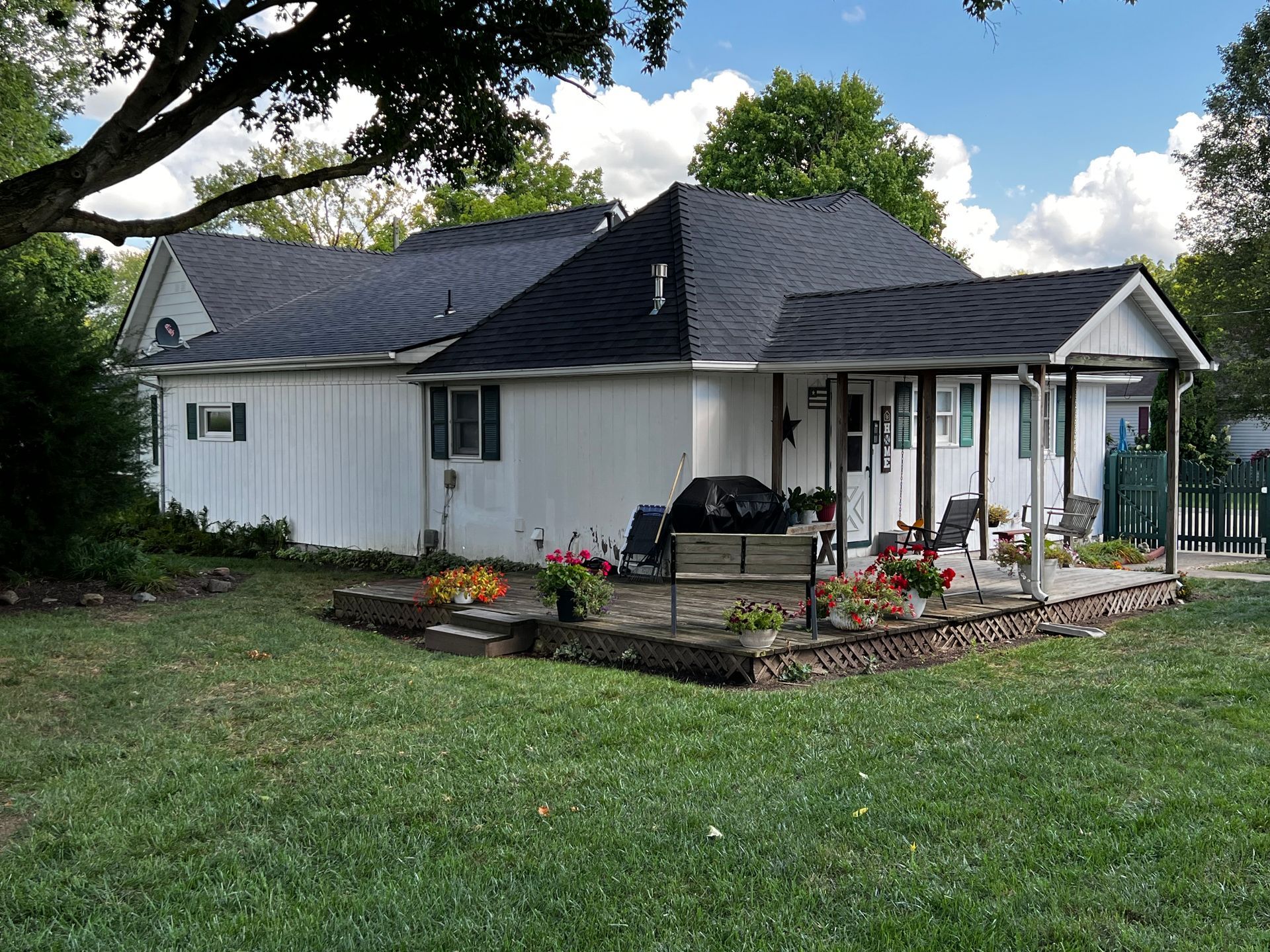A white house with a black roof and a porch