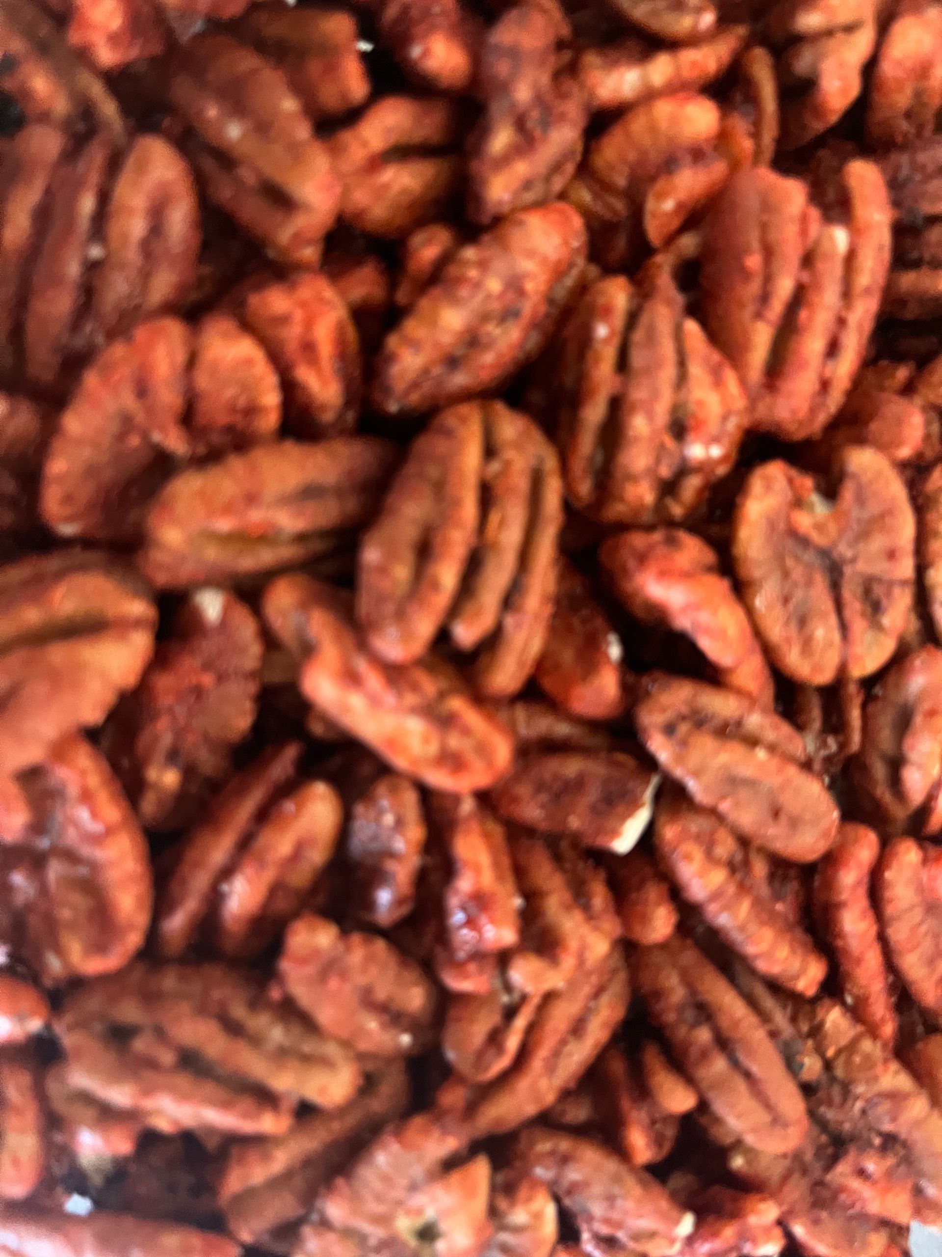 A close up of a pile of pecans on a table.