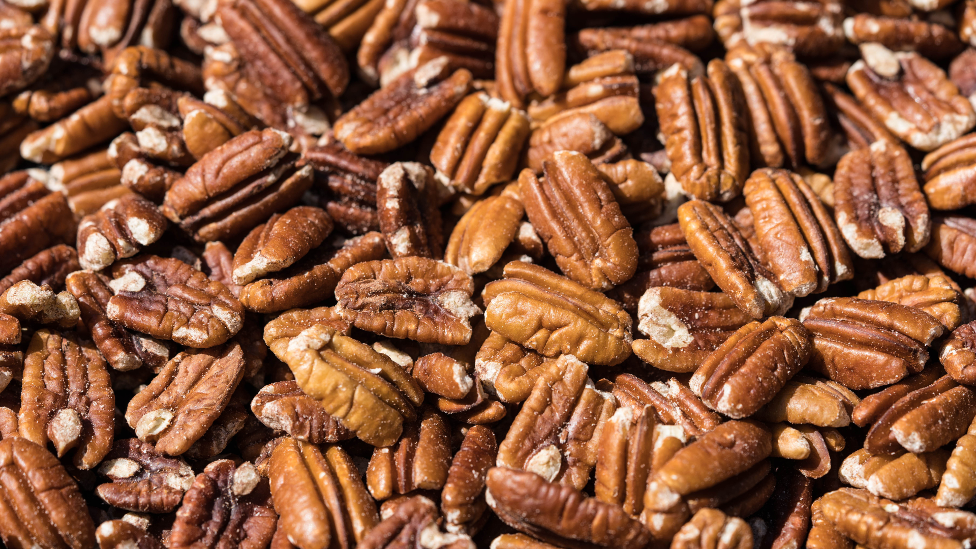 A pile of pecans sitting on top of each other on a table.