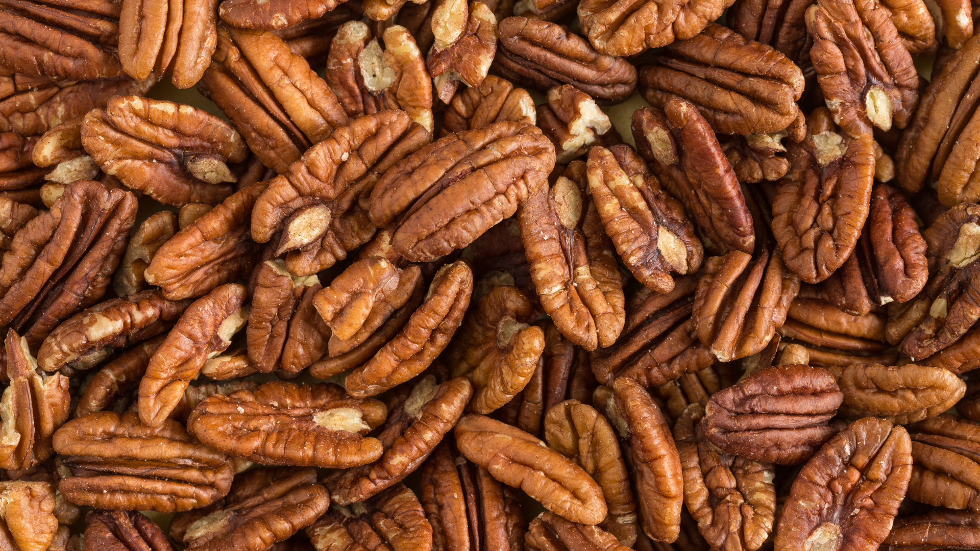 A pile of pecans sitting on top of each other on a table.