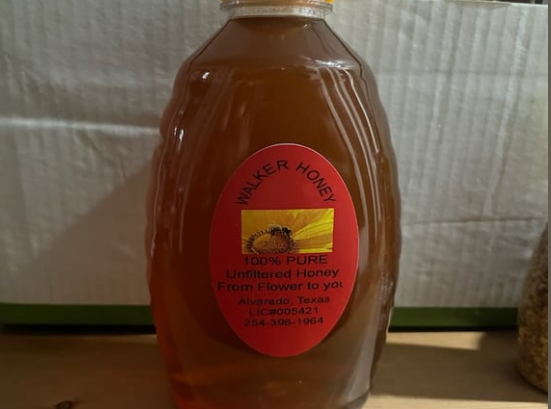 A bottle of walker honey sits on a table