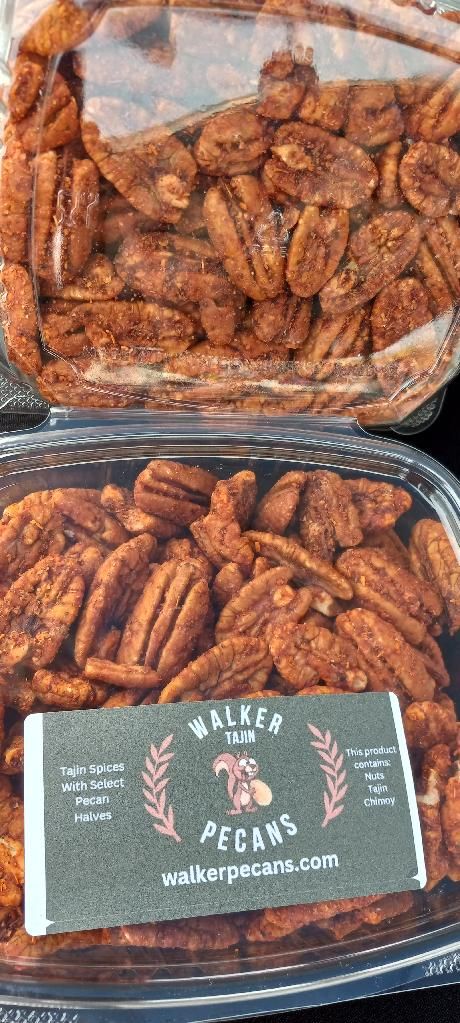 A plastic container filled with pecans with a label on it.