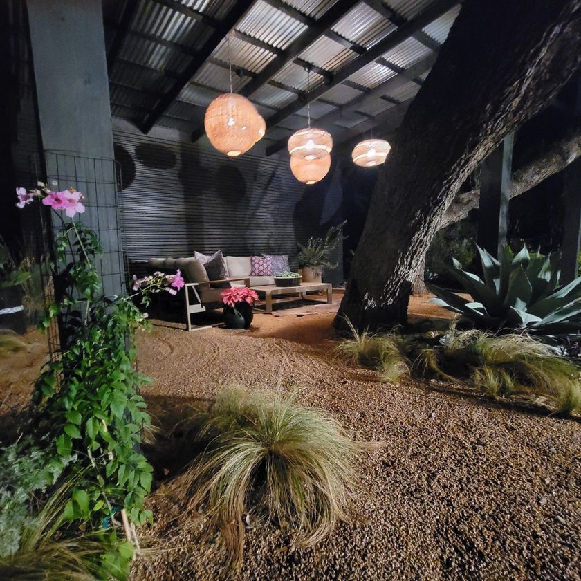 A patio area with a couch and chairs at night