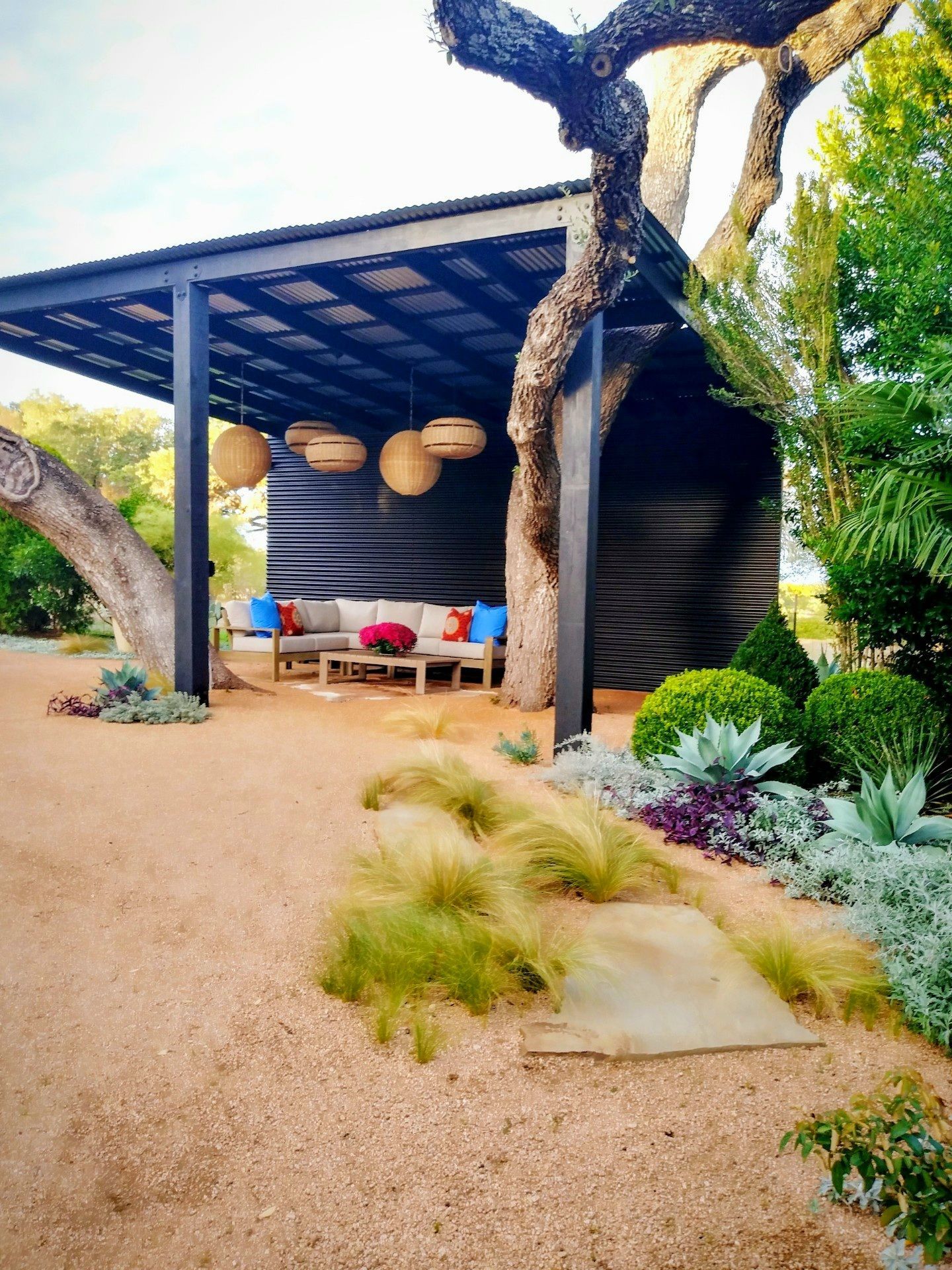 A pergola with a couch underneath it in a garden