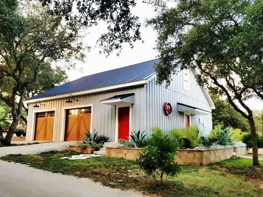 A white house with two garage doors and a red door