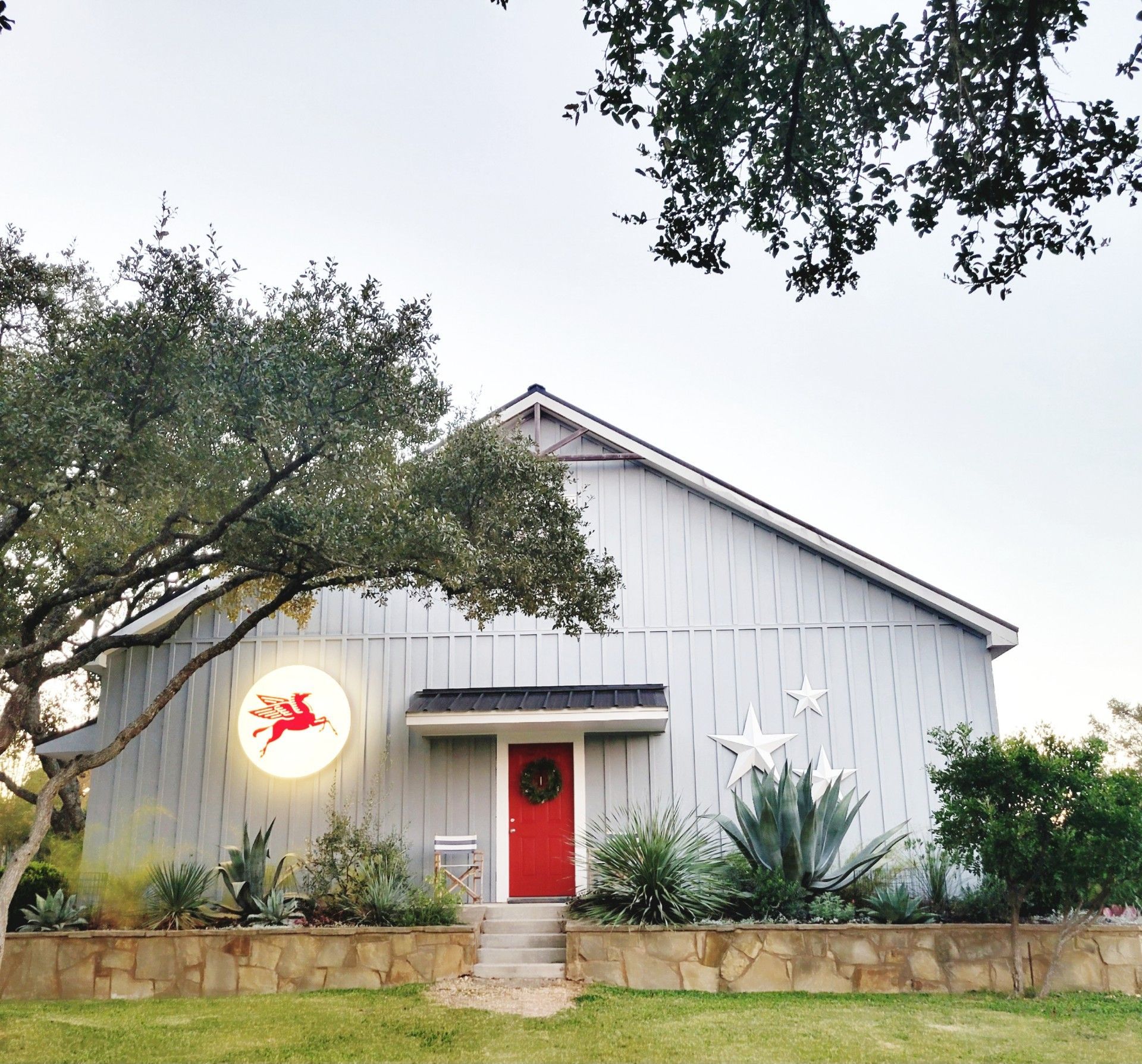 A white house with a red door and a light on the side