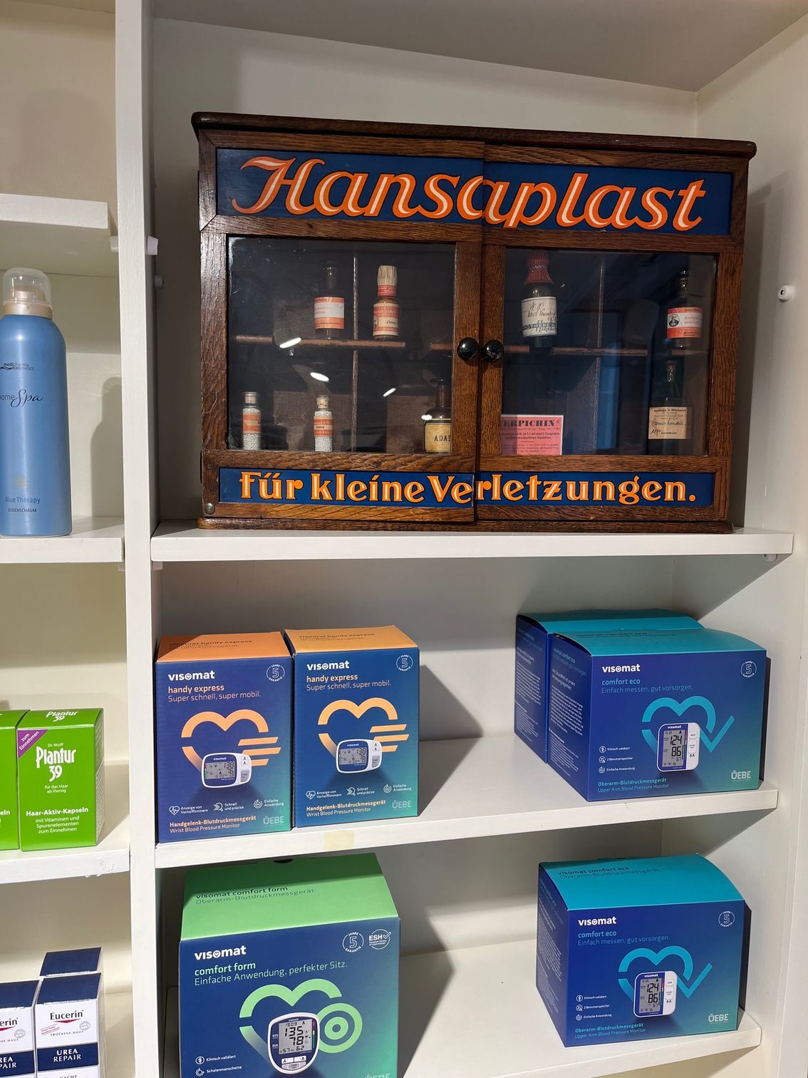 Ein Regal mit Schachteln von Hansaplast darauf