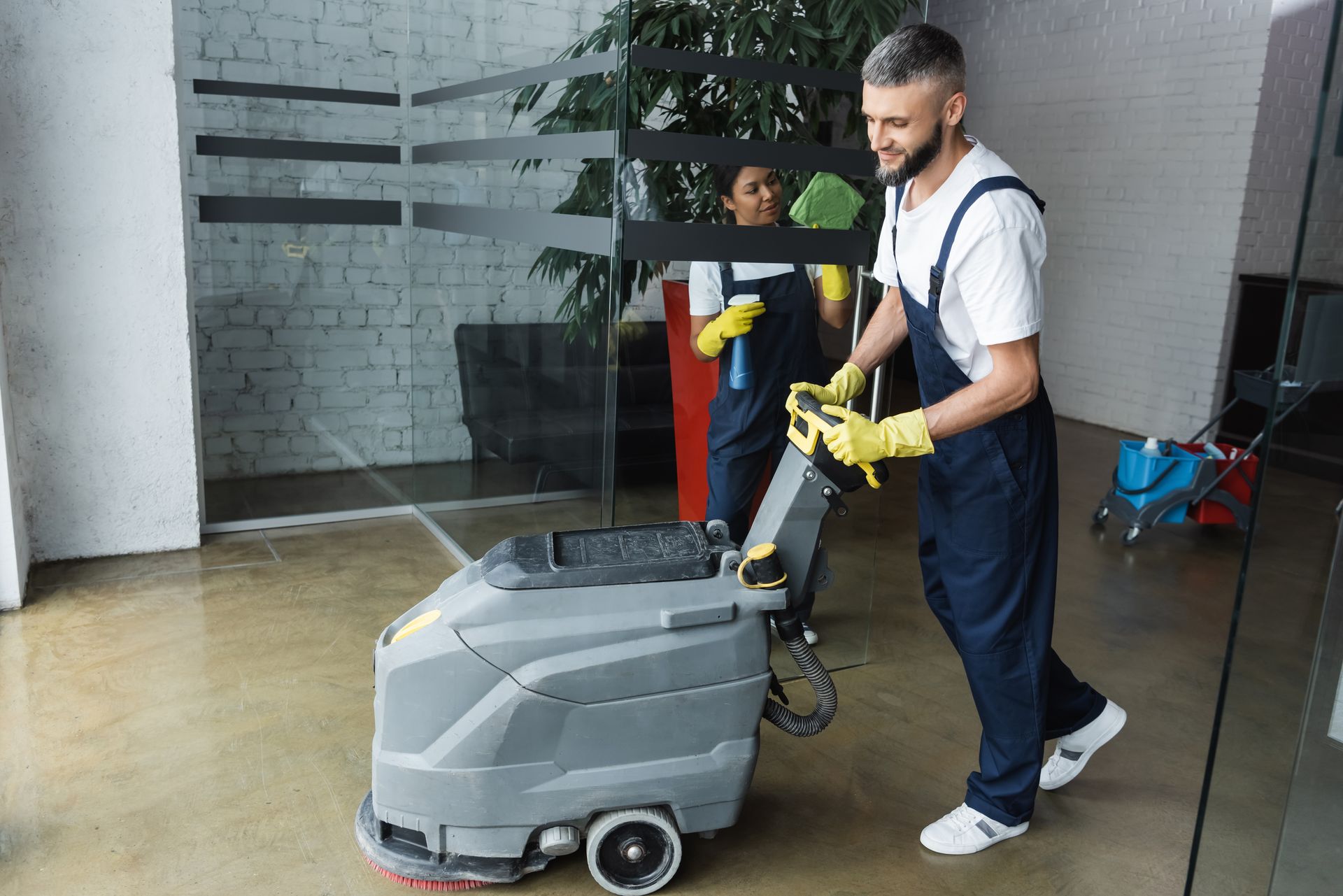 A man is cleaning the floor with a machine.