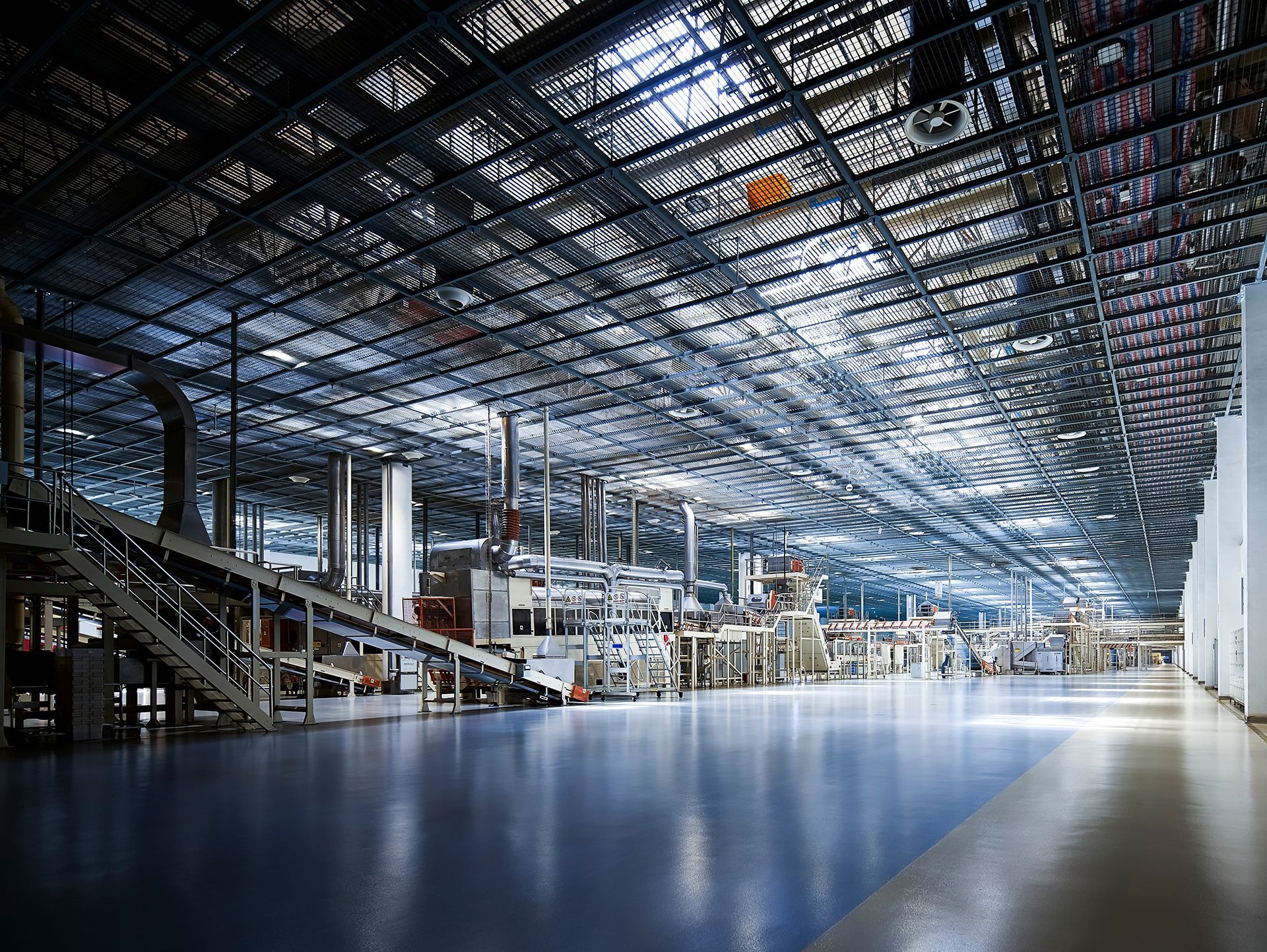 An empty factory with lots of machinery and a conveyor belt.