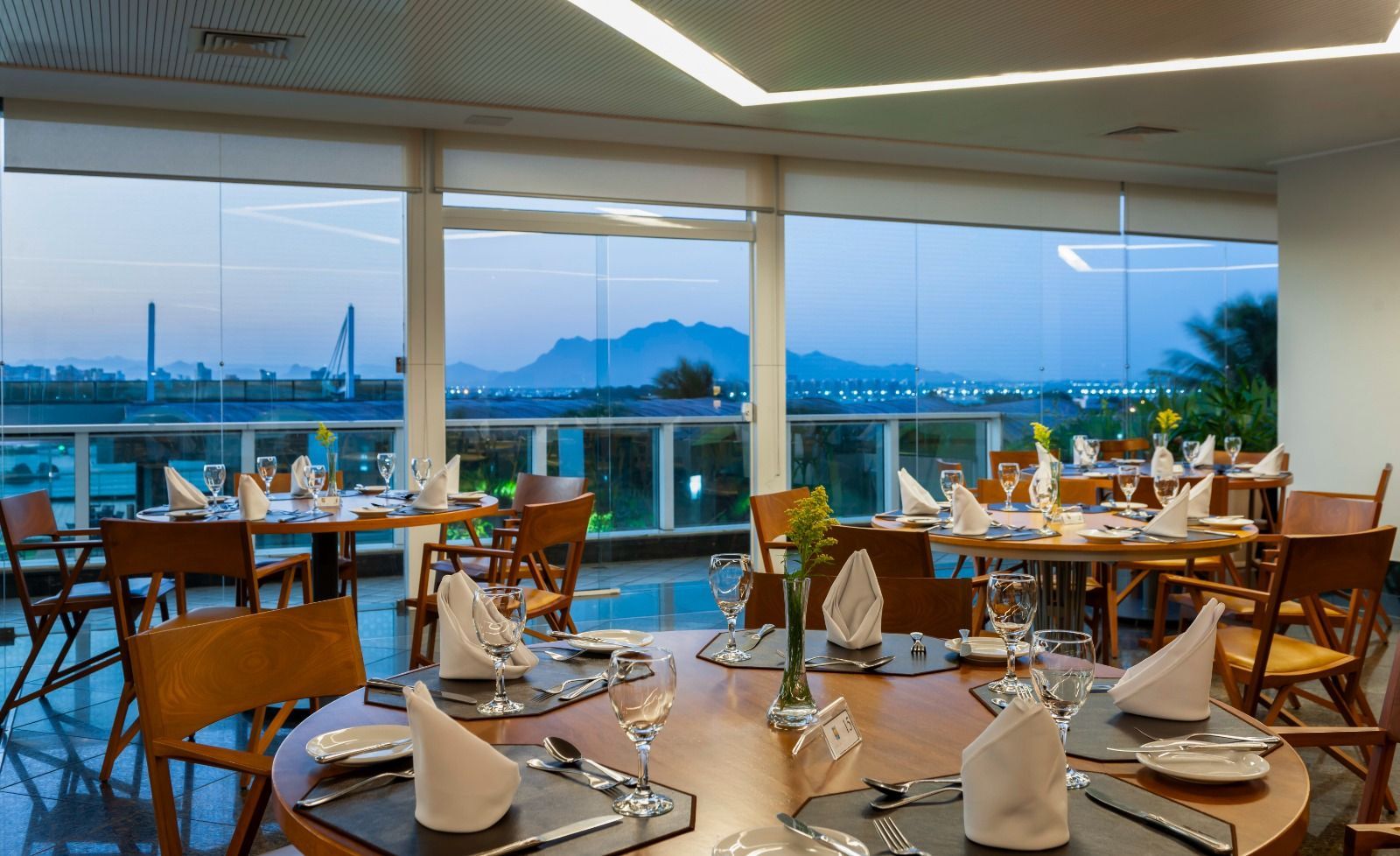 Um restaurante com mesas e cadeiras e vista para uma montanha