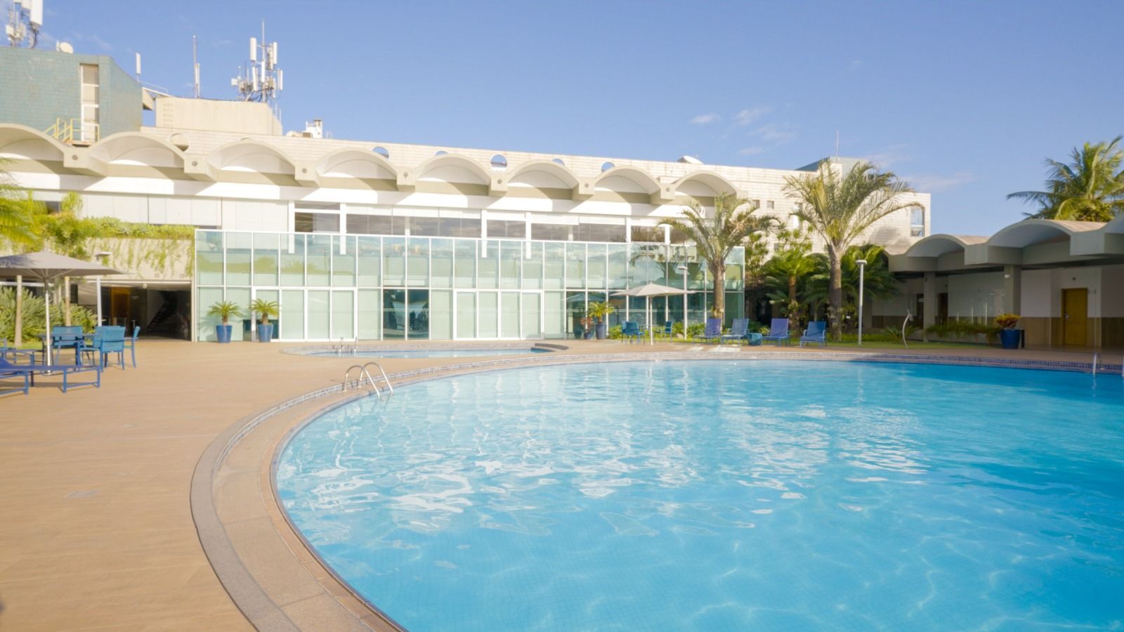 Há uma grande piscina em frente a um prédio.