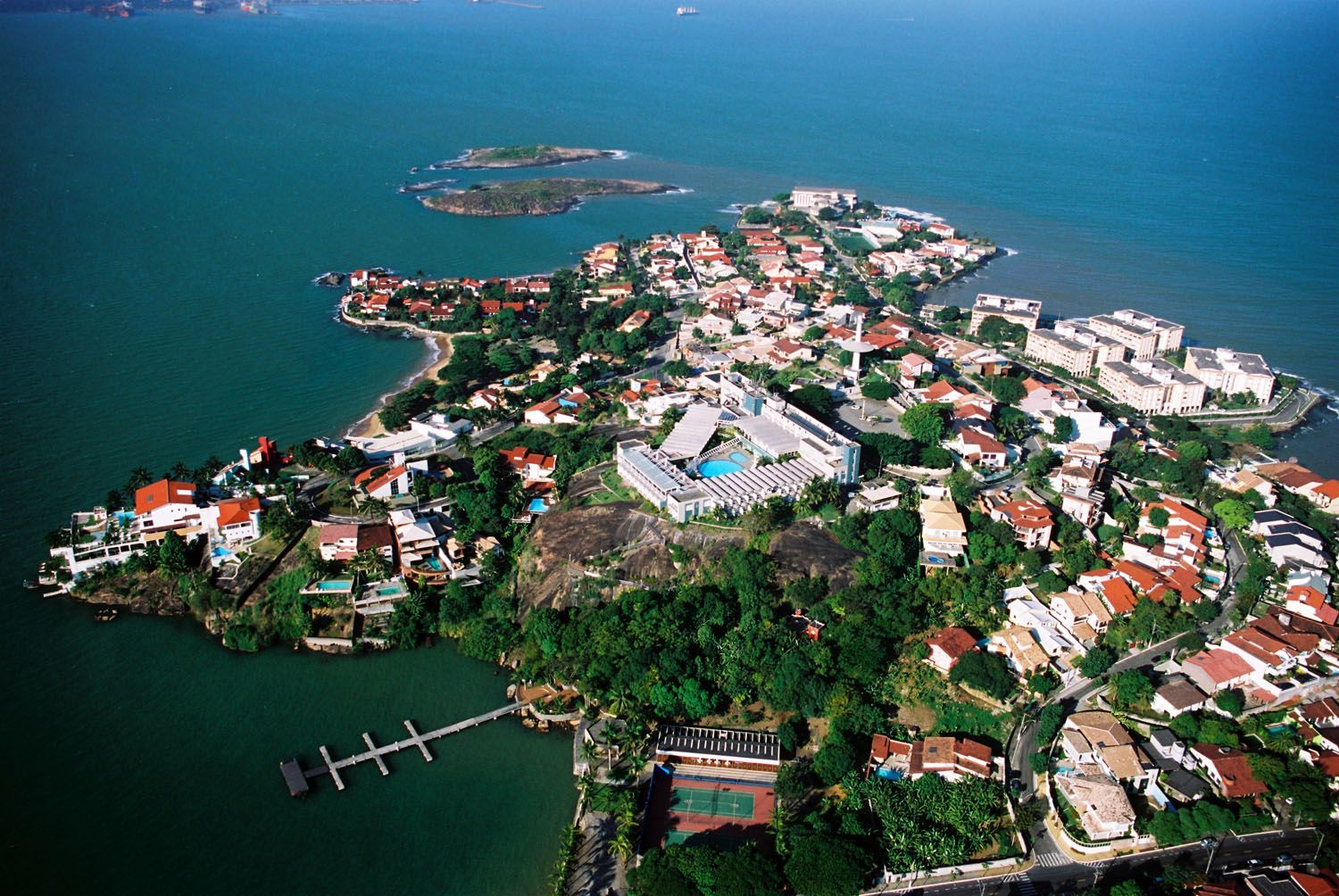 Uma vista aérea de uma pequena ilha no meio do oceano cercada por casas.
