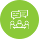 Three people seated at a table with two speech bubbles above, green circle.