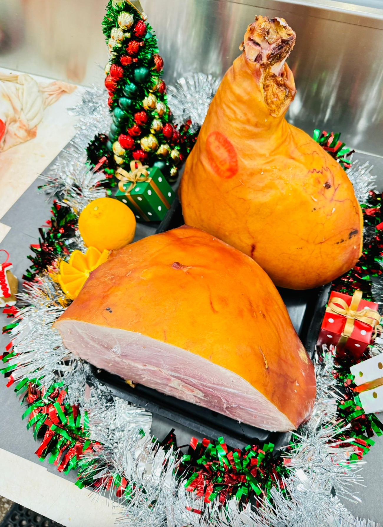 Two pieces of ham are sitting on a table with christmas decorations-Butcher in Darwin