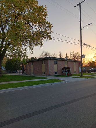 A brick building sits on the corner of a street at sunset