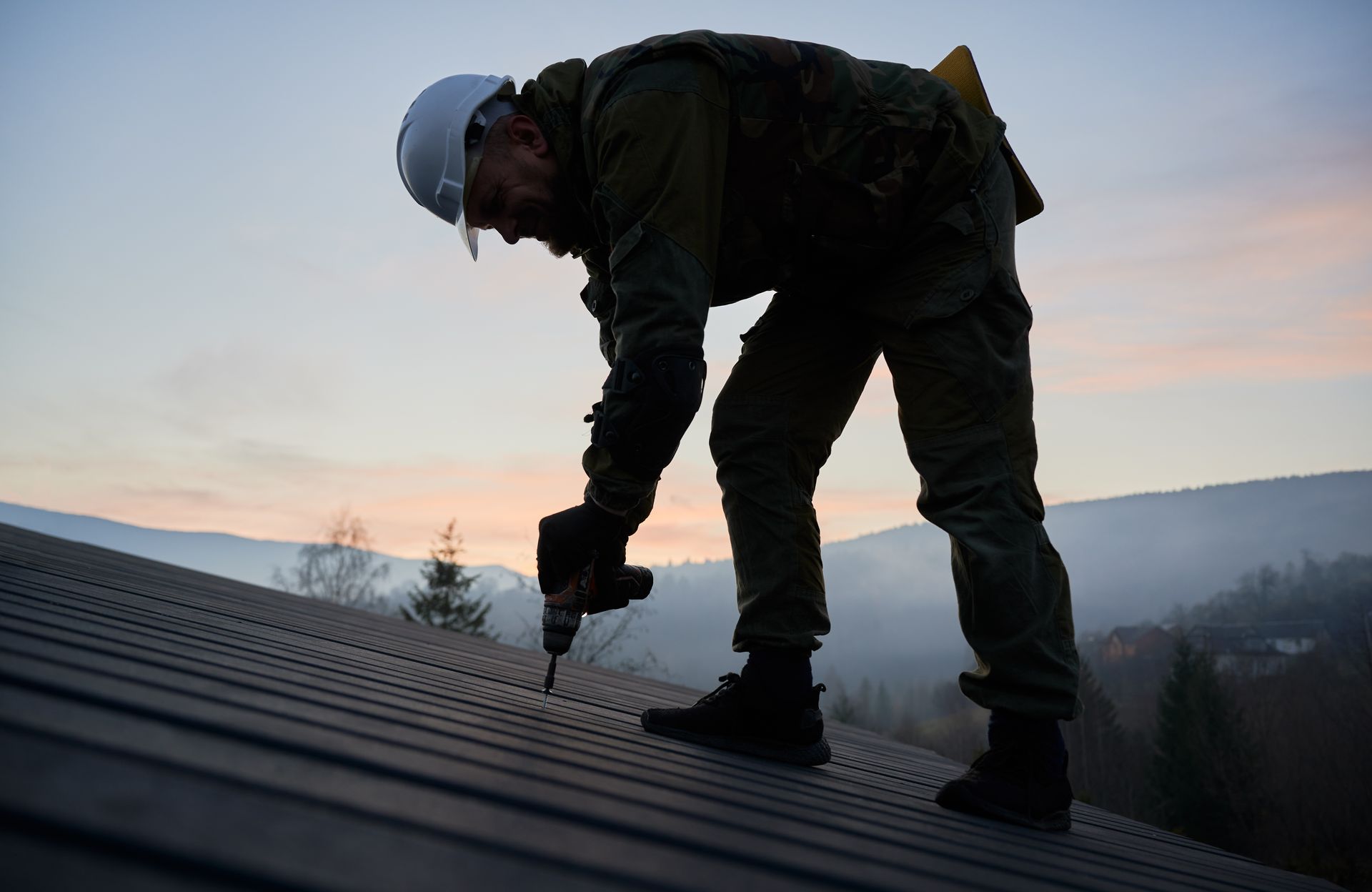 builder installing corrugated iron sheet