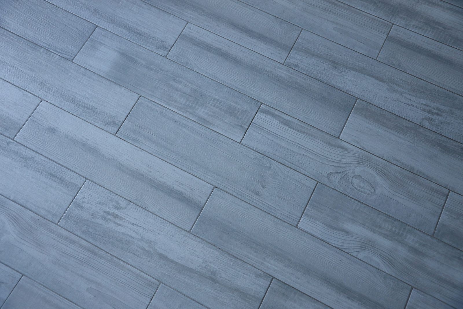 A close up of a wooden floor with a diagonal pattern.