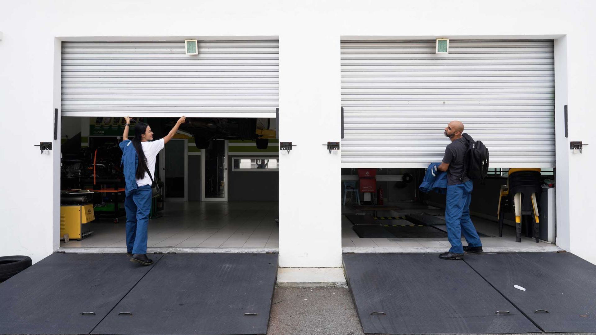 Two men are working on a garage door.