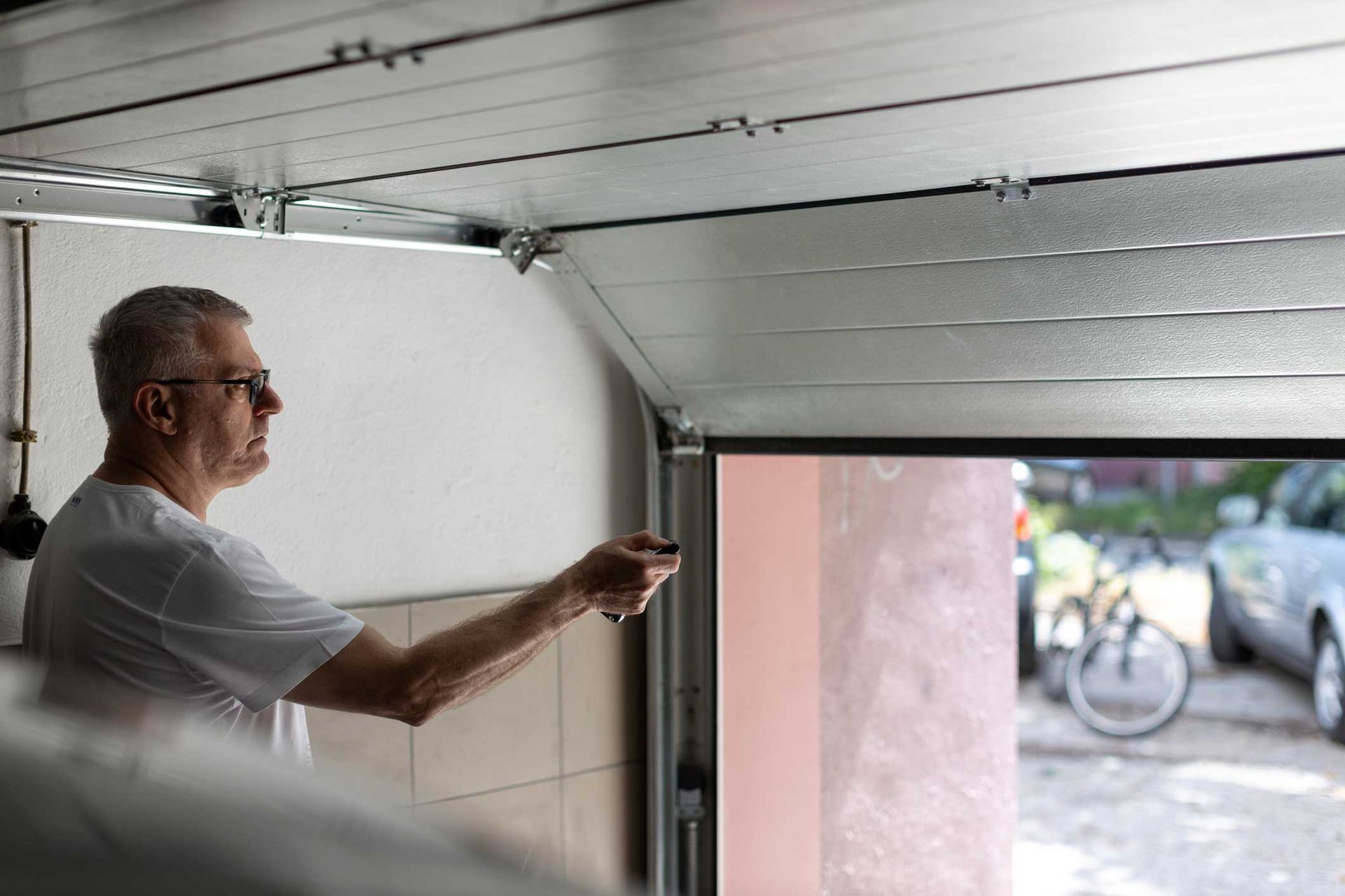 A man is opening a garage door with a remote control.