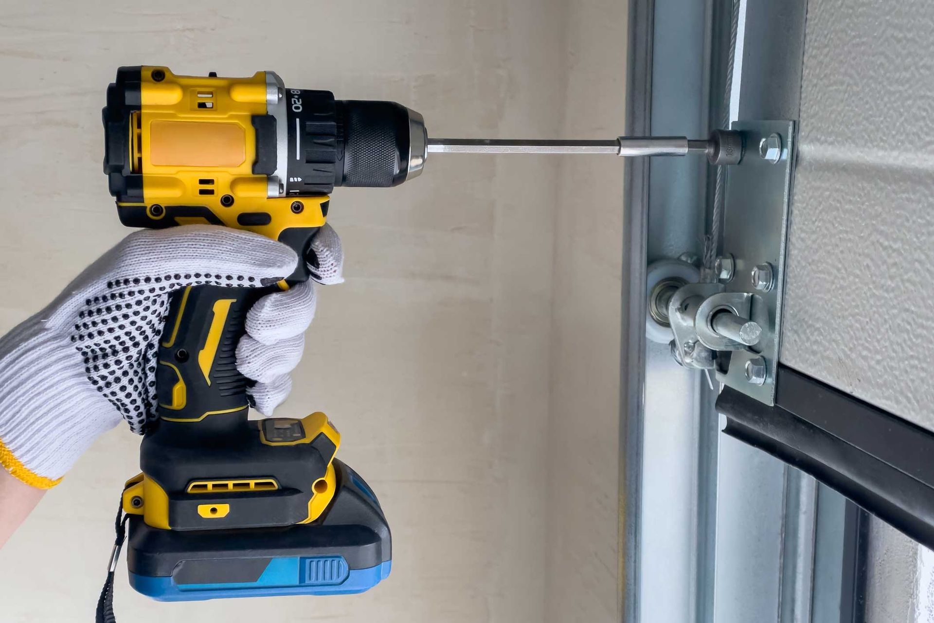 A person is using a drill to fix a garage door.