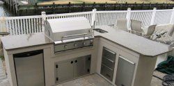  Backyard cooking area featuring grill and sink for outdoor dining.