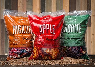 Three bags of wood pellet varieties on a table.