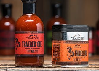 Various Traeger BBQ sauce bottles and other products displayed on a table.
