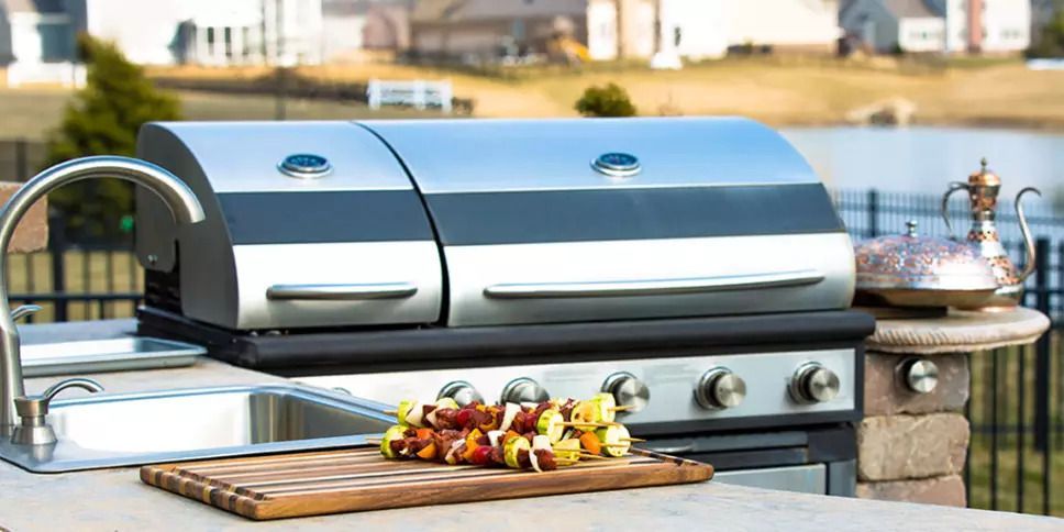 Image of an outdoor kitchen setup with a grill and sink, ideal for cooking and socializing outdoors.