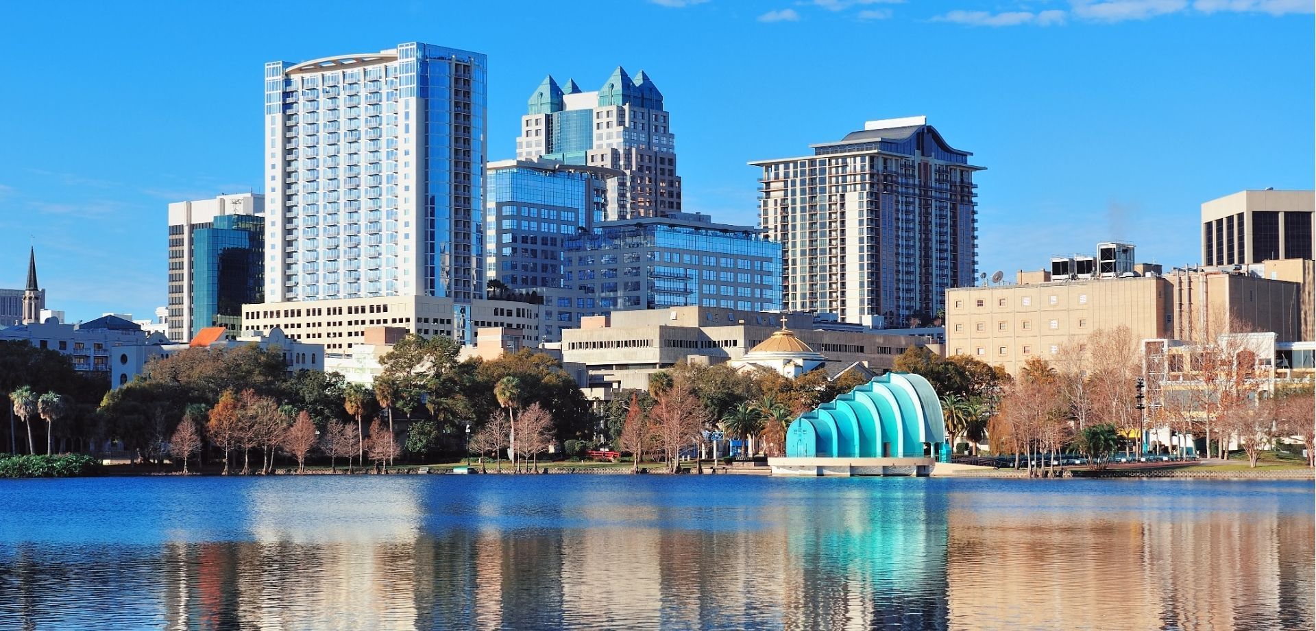A city skyline with a lake in the foreground