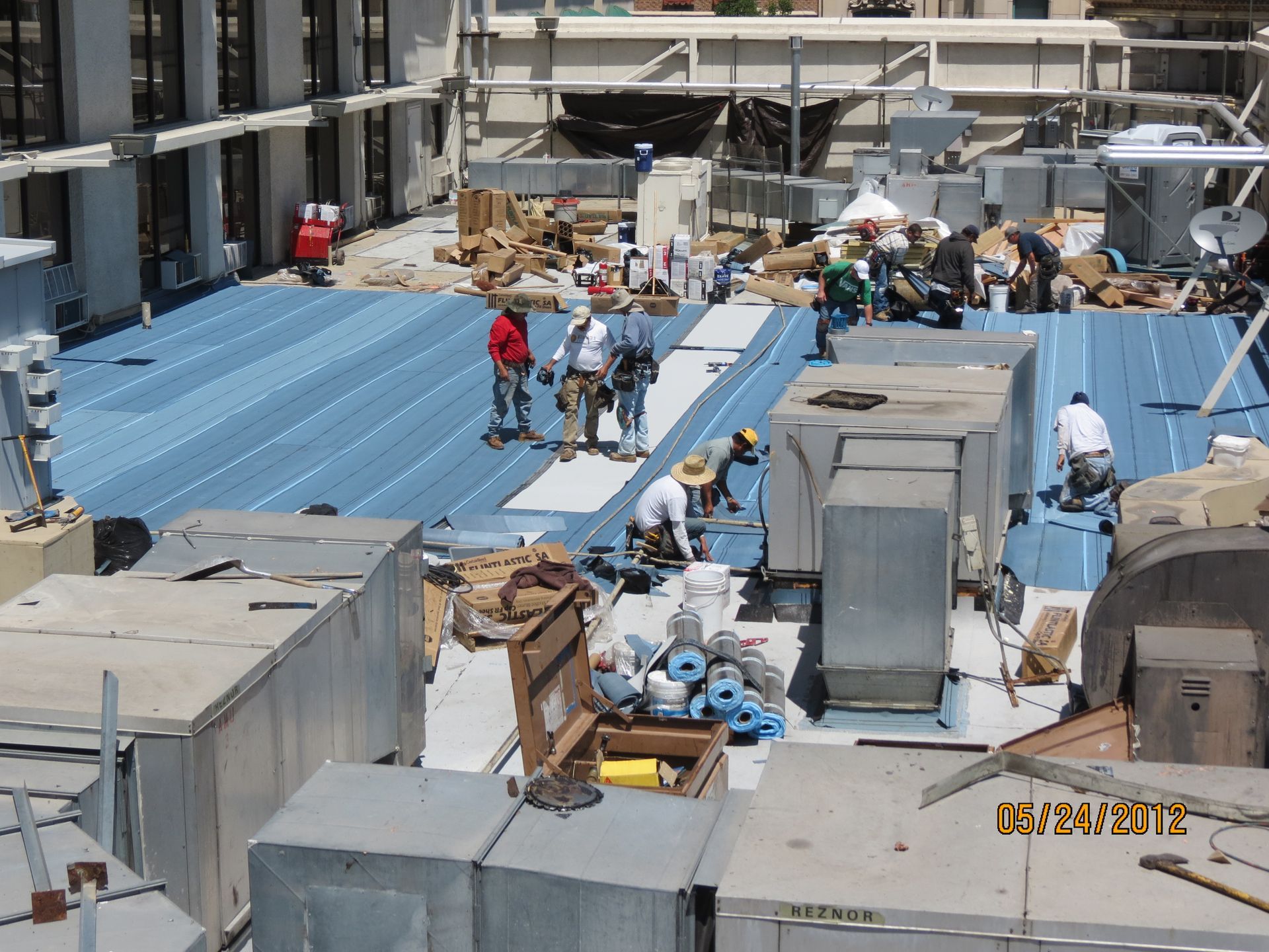 A group of men are working on the roof of a building