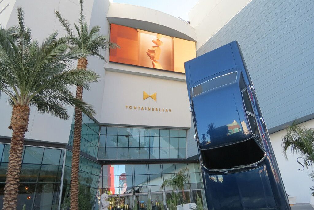 A statue of a car in front of a building that says fontainebleau
