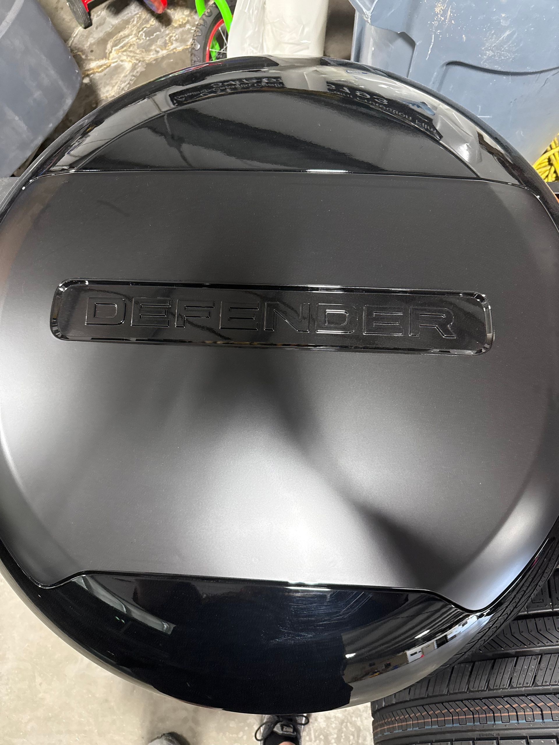 A black tire cover is sitting on top of a tire.