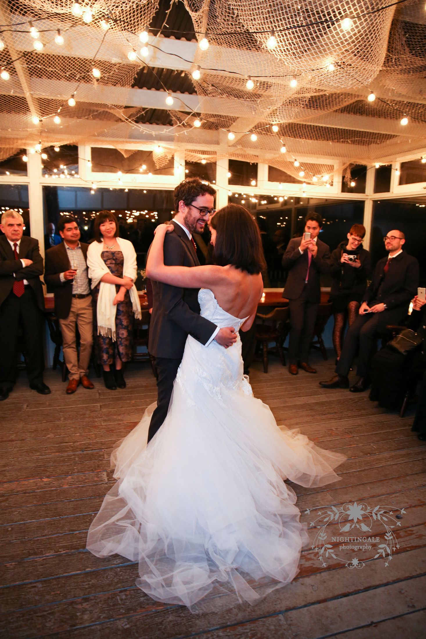 A bride and groom are dancing at their wedding reception