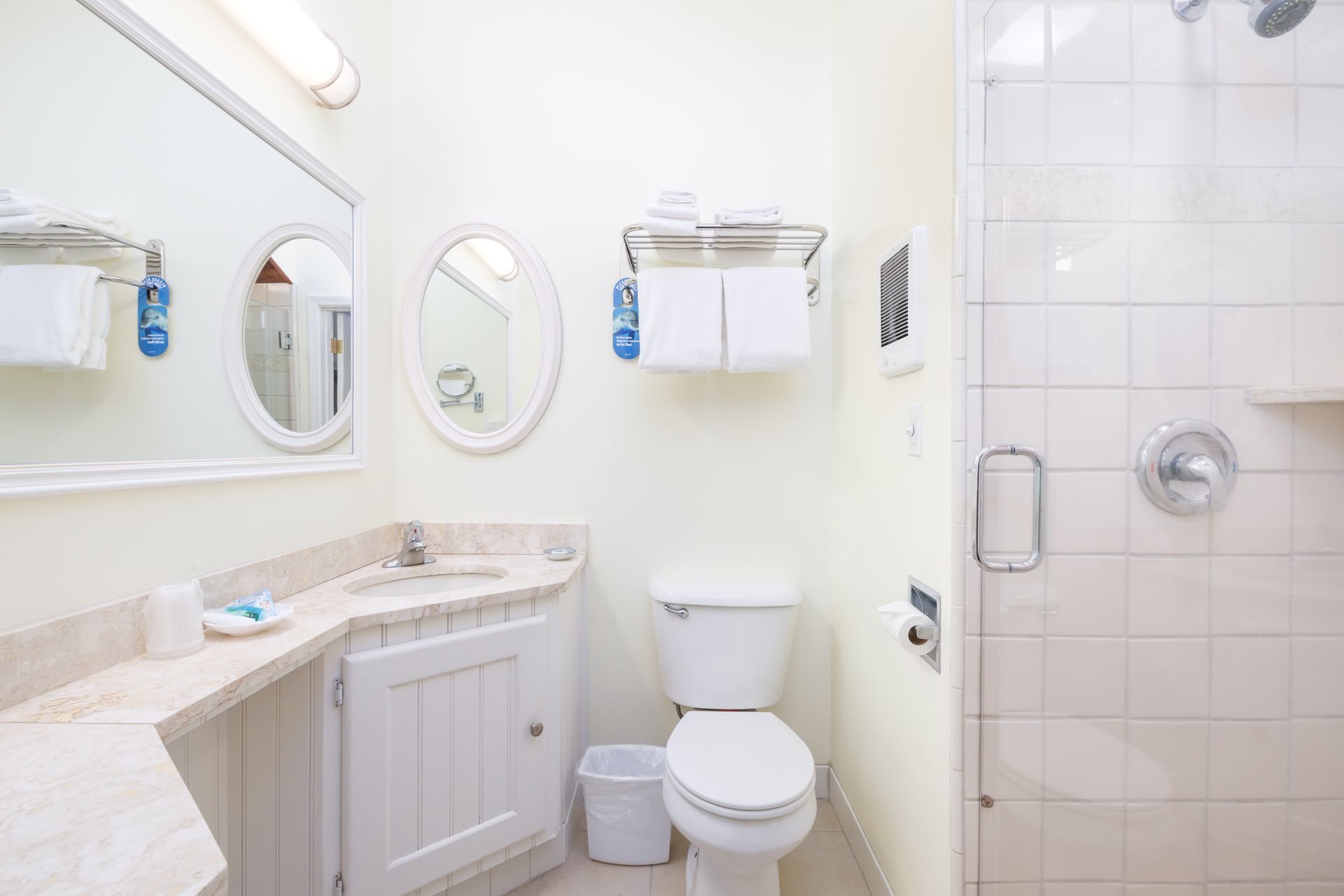 A bathroom with a toilet , sink , mirror and shower.